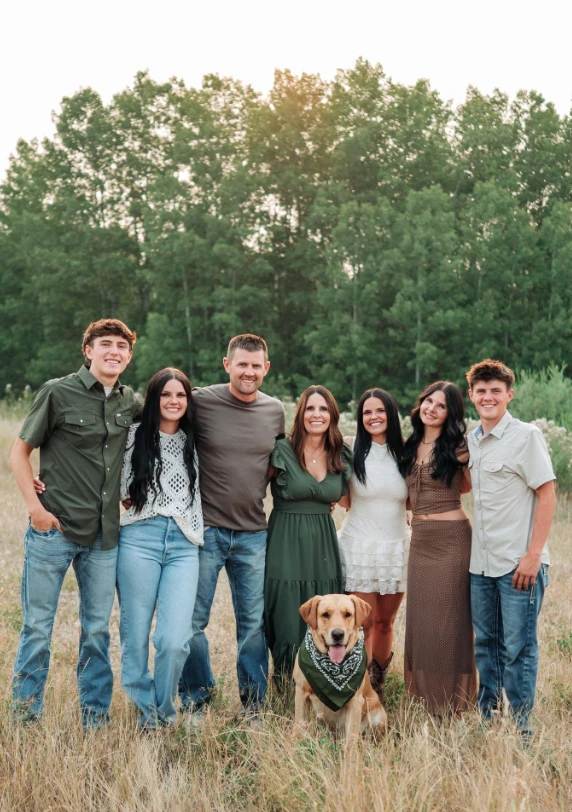 Lori and Matt Clyde with their five children and their dog Bodie in a grassy field
